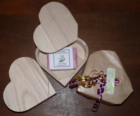 Un savon dans une boite cœur en bois naturel, le tout enveloppé d'un papier cadeau
